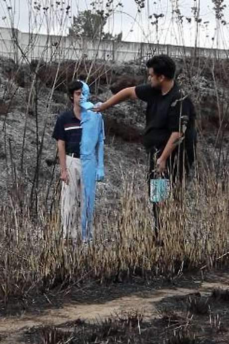 A performance video by Naufus Ramírez-Figueroa, this work presents a young man standing still beside a rural road. The artist approaches, using blue paint and a brush to cover the man’s clothing and body in broad strokes. The video, filmed in a continuous six-and-a-half-minute take, explores themes of disappearance and historical cinema, referencing how early film stock often rendered blue objects white. The artist ultimately walks away, leaving the painted figure standing motionless in the landscape.